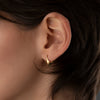 Gold-Edgy-Huggie-Earrings-On-Ear