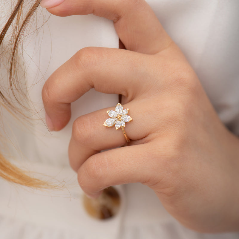 Asymmetric-Blossom-Engagement-Ring-with-Pear-Cut-Diamonds-on-finger