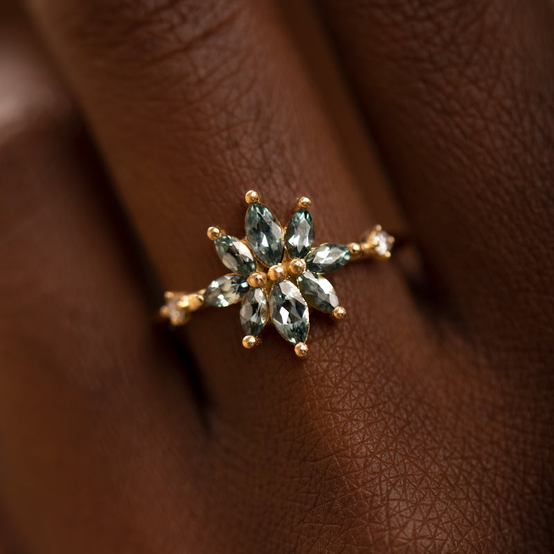 Bouquet-Engagement-Ring-with-Teal-Sapphire-and-Diamond-Petals-on-finger