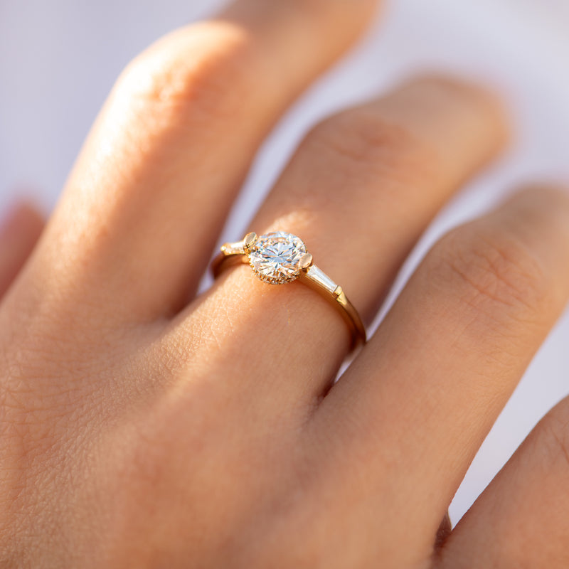 Brilliant-Cut-Engagement-Ring-with-a-Pave-Diamond-Halo-on-finger