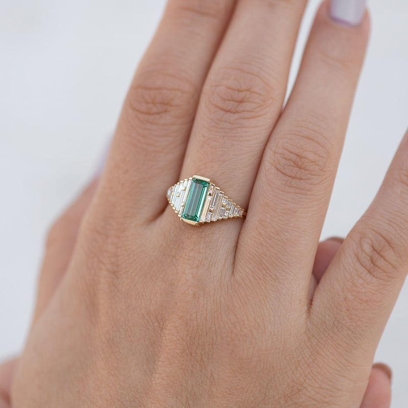 Emerald Ring with needle baguette Diamonds one hand.jpg