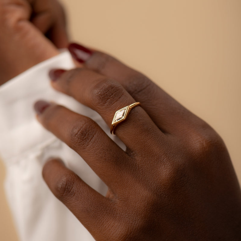Lozenge-Cut-Diamond-Engagement-Ring-with-a-Golden-Bezel-sparking