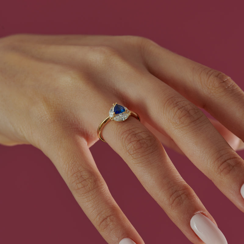 Marquise-Diamond-and-Royal-Blue-Trillion-Sapphire-Engagement-Ring-side-shot-on-finger