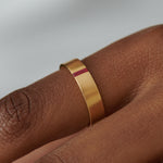 Ruby-Baguette-Unisex-Matte-Gold-Wedding-Band-on-finger-solid-gold