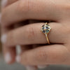 Teal-Sapphire-and-Diamond-Cluster-Engagement-Ring-side-shot-on-finger