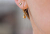 Tiny Cube Gold Earrings On Ears