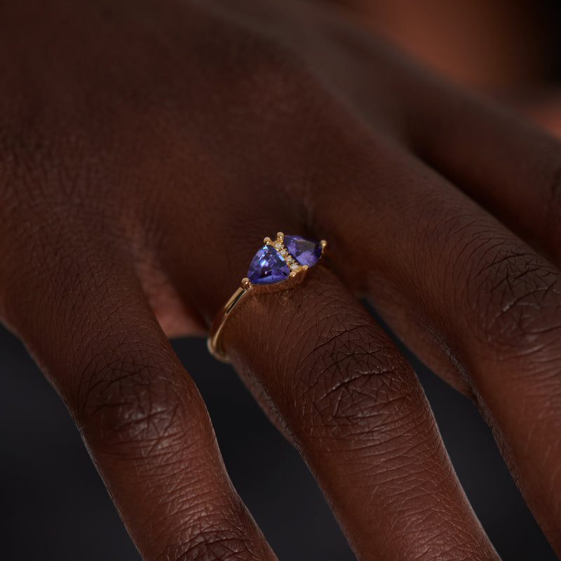 Vintage-Style-Engagement-Ring-with-Trillions-and-Brilliant-Diamonds-closeup-tanzanite-on-finger