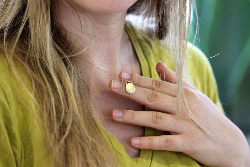Gold Whale Necklace on a hand